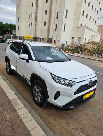 מונית מכל יעד לנתב''ג - חזית מונית טויוטה ראב 4 לבנה בהמתנה לנסיעה
